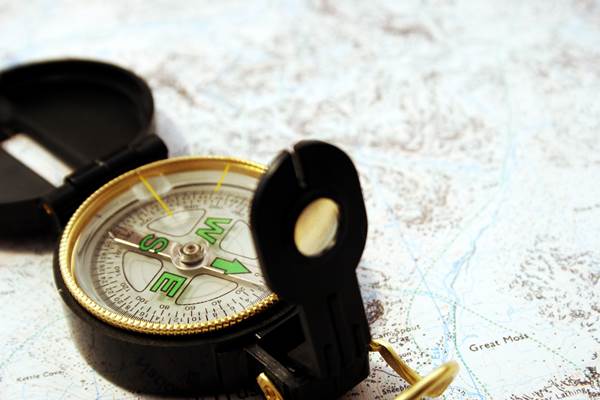 An Explorer's Compass Lying on Top of a Map