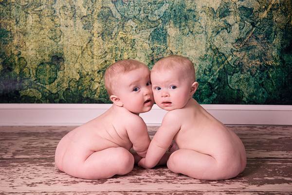Two Very Cute Babies Sitting with Cheeks Together