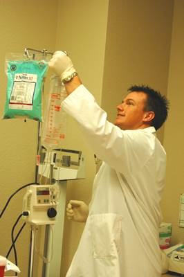A Male Nurse Checking IV Fluid of a Patient
