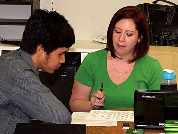 An Employment Counselor Guiding a Student Through His Resume Writing