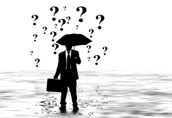 Silhouette Image of a Professional Surrounded by Question Marks