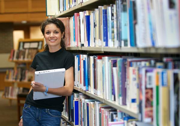 Girl Student Holding Her Laptop in a Library