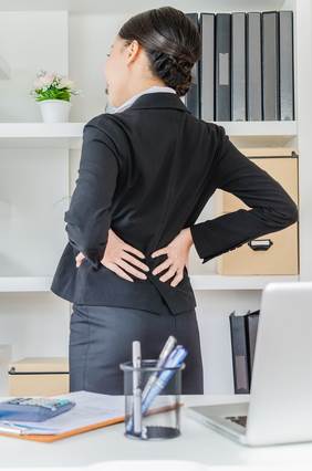 Woman Holding Her Aching Back at Work